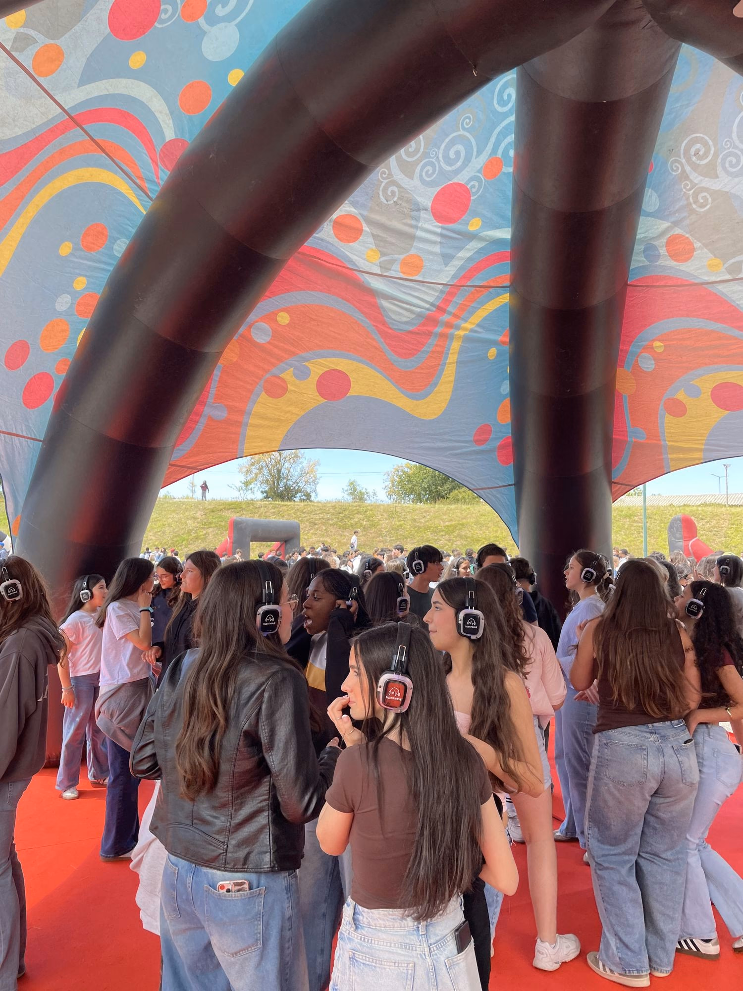 Jovens com auscultadores SilentWave sob a tenda insuflável no EMRC 2026