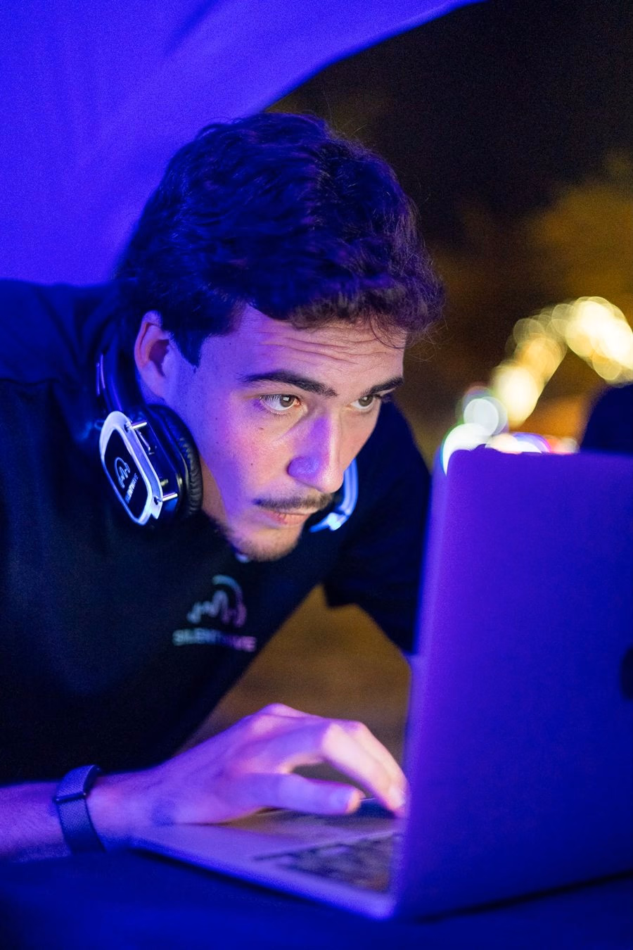 André Delimbeuf, co-fundador da SilentWave, com auscultadores ao pescoço, ao computador durante um evento