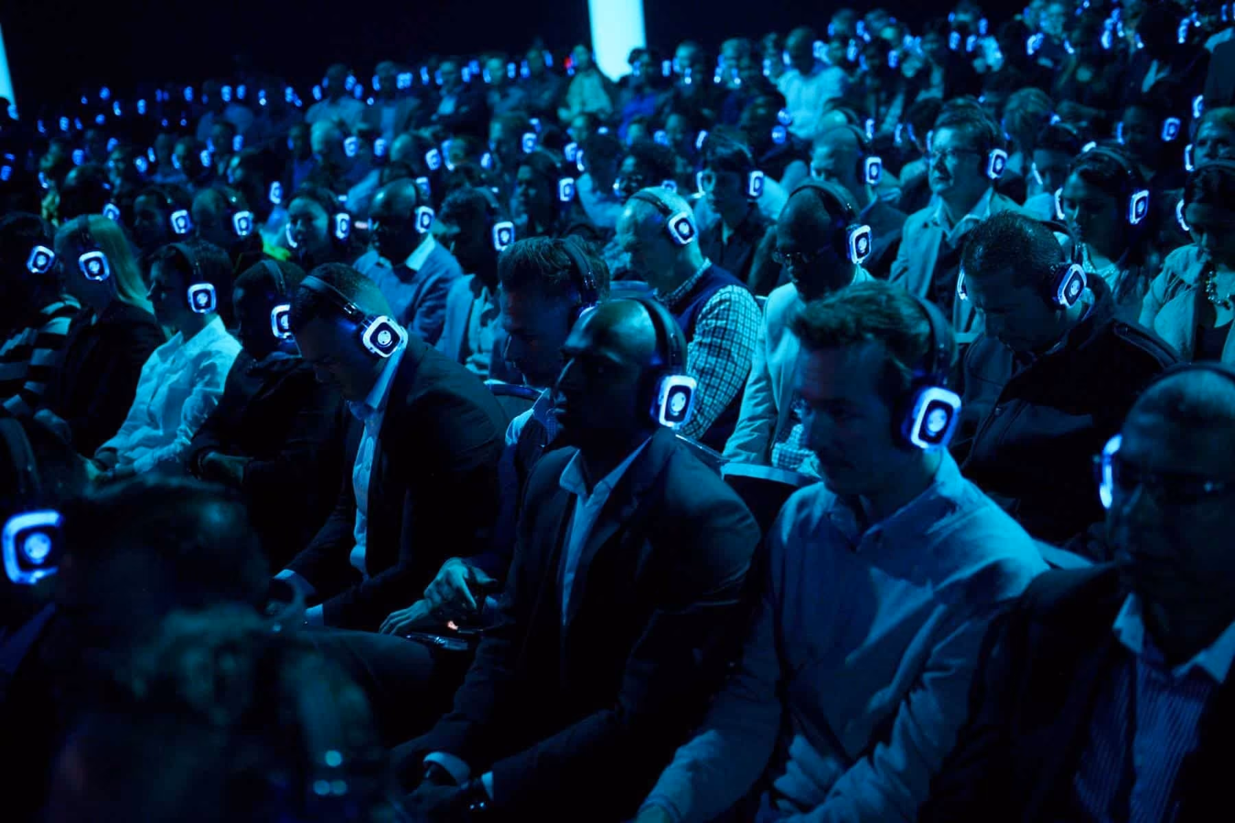 Plateia de uma conferência a ouvir com auscultadores SilentWave